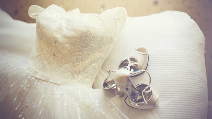A wedding dress and shoes displayed.