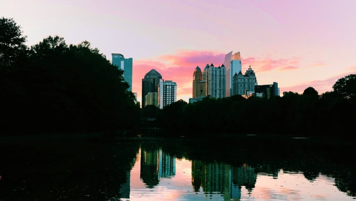 Skyline reflecting off of a lake at sunset in Piedmont Park in Atlanta, Georgia.