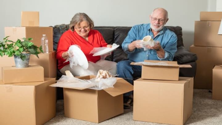 A retired couple unpacking moving boxes in their new home.