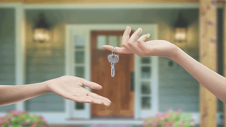 A realtor handing keys to a new homeowner.