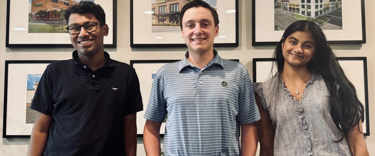 3 interns standing together in an office