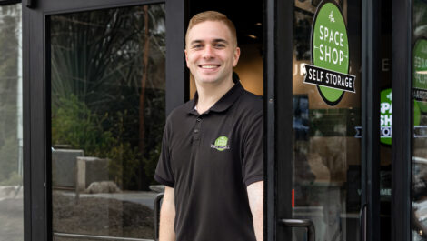 Employee at Space Shop Self Storage opening door to welcome customer into leasing office